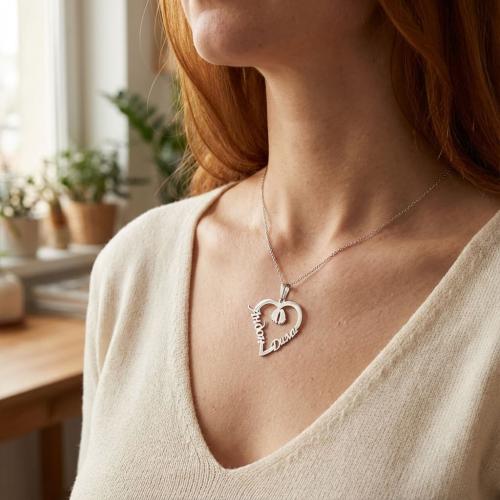 Сребърно колие във формата на сърце с две имена по избор и бебешки стъпки в средата