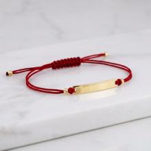 Гривна с червен конец и 14 карата златен елемент плочка с гравирано име Гривна с червен конец и 14 карата златен елемент плочка с гравирано име