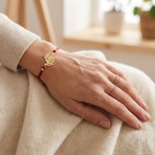 Гривна с червен конец и 14 карата златен елемент 2 бебешки стъпки Гривна с червен конец и 14 карата златен елемент 2 бебешки стъпки