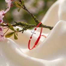 Гривна с червен конец и сребърен елемент кръст