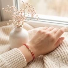 Гривна с червен конец и 14 карата златен елемент кръст