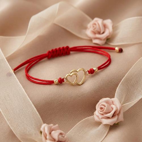 Гривна с червен конец и златен елемент две сърца