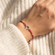 Гривна с червен конец и сребърен елемент подкова