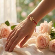 Гривна с червен конец и 14 карата златен елемент корона с гравирано послание Гривна с червен конец и 14 карата златен елемент корона с гравирано послание