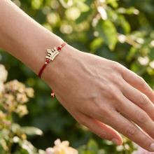 Гривна с червен конец и 14 карата златен елемент корона с гравирано послание Гривна с червен конец и 14 карата златен елемент корона с гравирано послание