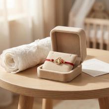 Гривна с червен конец и 14 карата златно сърце с бебешки стъпки