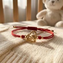 Гривна с червен конец и 14 карата златно сърце с бебешки стъпки