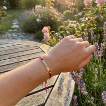 Гривна с червен конец и 14 карата златен елемент плочка с гравирано име