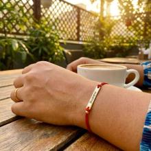 Гривна с червен конец и 14 карата златен елемент плочка с гравирано име