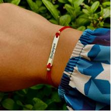 Гривна с червен конец и 14 карата златен елемент плочка с гравирано име