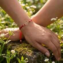 Гривна с червен конец и 14 карата златен елемент детелинка Гривна с червен конец и 14 карата златен елемент детелинка