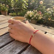 Гривна с червен конец и 14 карата златен елемент детелинка Гривна с червен конец и 14 карата златен елемент детелинка