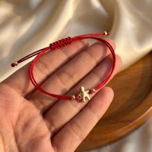 Гривна с червен конец и 14 карата златна фигура момче