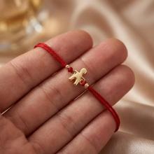 Гривна с червен конец и 14 карата златна фигура момче