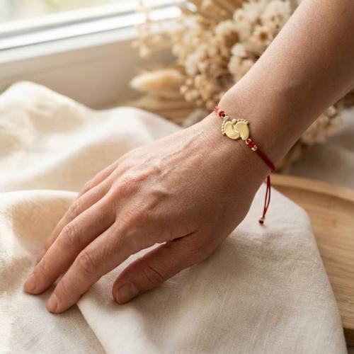 Гривна с червен конец и 14 карата златен елемент 2 бебешки стъпки 