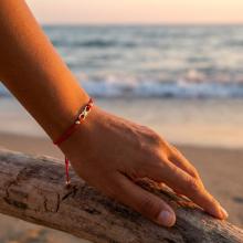 Гривна с червен конец и 14 карата златен елемент безкрайност