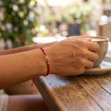 Гривна с червен конец и 14 карата златен елемент безкрайност