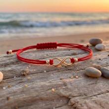 Гривна с червен конец и 14 карата златен елемент безкрайност