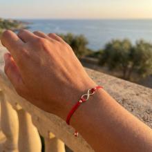 Гривна с червен конец и 14 карата златен елемент безкрайност