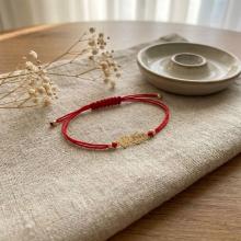 Гривна с червен конец и 14 карата златен елемент момче