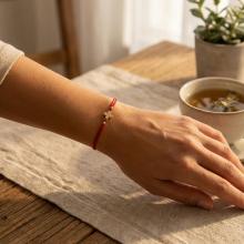 Гривна с червен конец и 14 карата златен елемент кръст