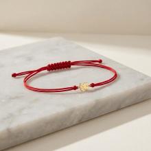 Гривна с червен конец и 14 карата златен елемент мече Гривна с червен конец и 14 карата златен елемент мече