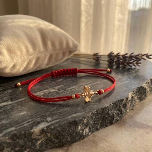 Гривна с червен конец и 14 карата златен елемент пчеличка