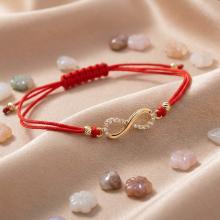 Гривна с червен конец и златен елемент безкрайност