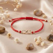 Гривна с червен конец и златен елемент безкрайност