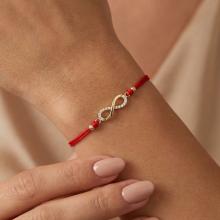 Гривна с червен конец и златен елемент безкрайност