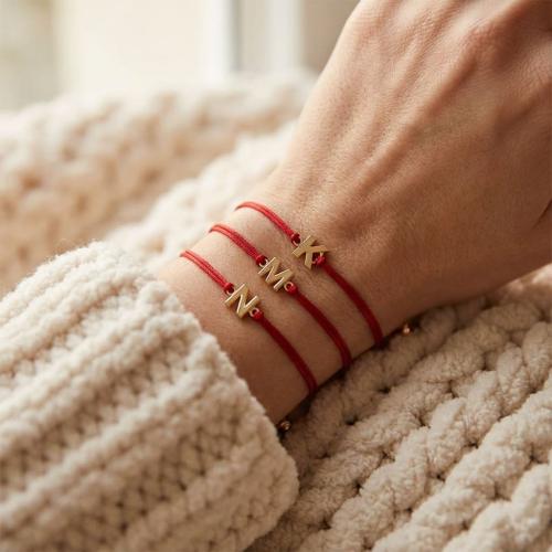 Гривна с червен конец и златни инициали