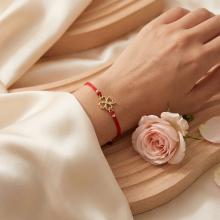 Гривна с червен конец и 14 карата златен елемент детелинка с циркон