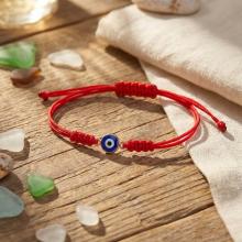 Гривна с червен конец и златен елемент синьо око