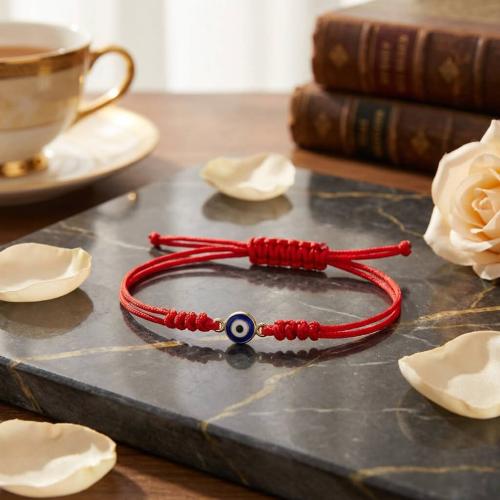 Гривна с червен конец и златен елемент синьо око