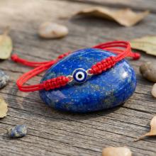 Гривна с червен конец и златен елемент синьо око