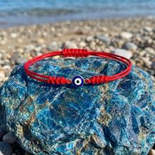 Гривна с червен конец и златен елемент синьо око