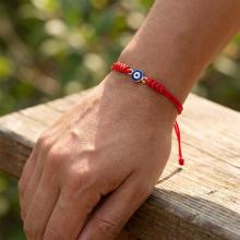 Гривна с червен конец и златен елемент синьо око