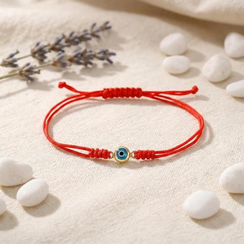 Гривна с червен конец и златен елемент синьо око