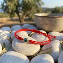 Гривна с червен конец и златен елемент синьо око