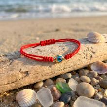 Гривна с червен конец и златен елемент синьо око