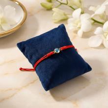 Гривна с червен конец и златен елемент синьо око