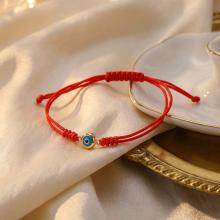 Гривна с червен конец и златен елемент синьо око