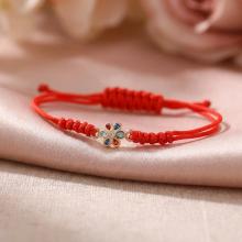 Гривна с червен конец и златен елемент цвете