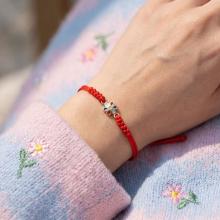 Гривна с червен конец и златен елемент цвете