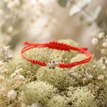 Гривна с червен конец и златен елемент цвете