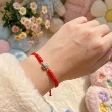 Гривна с червен конец и златен елемент цвете