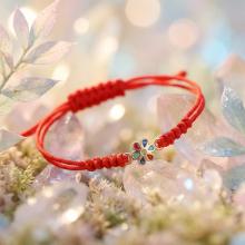 Гривна с червен конец и златен елемент цвете