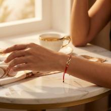 Гривна с червен конец и 14 карата златен елемент безкрайност