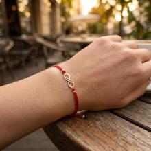 Гривна с червен конец и 14 карата златен елемент безкрайност