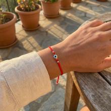 Гривна с червен конец и златен елемент синьо око BT41